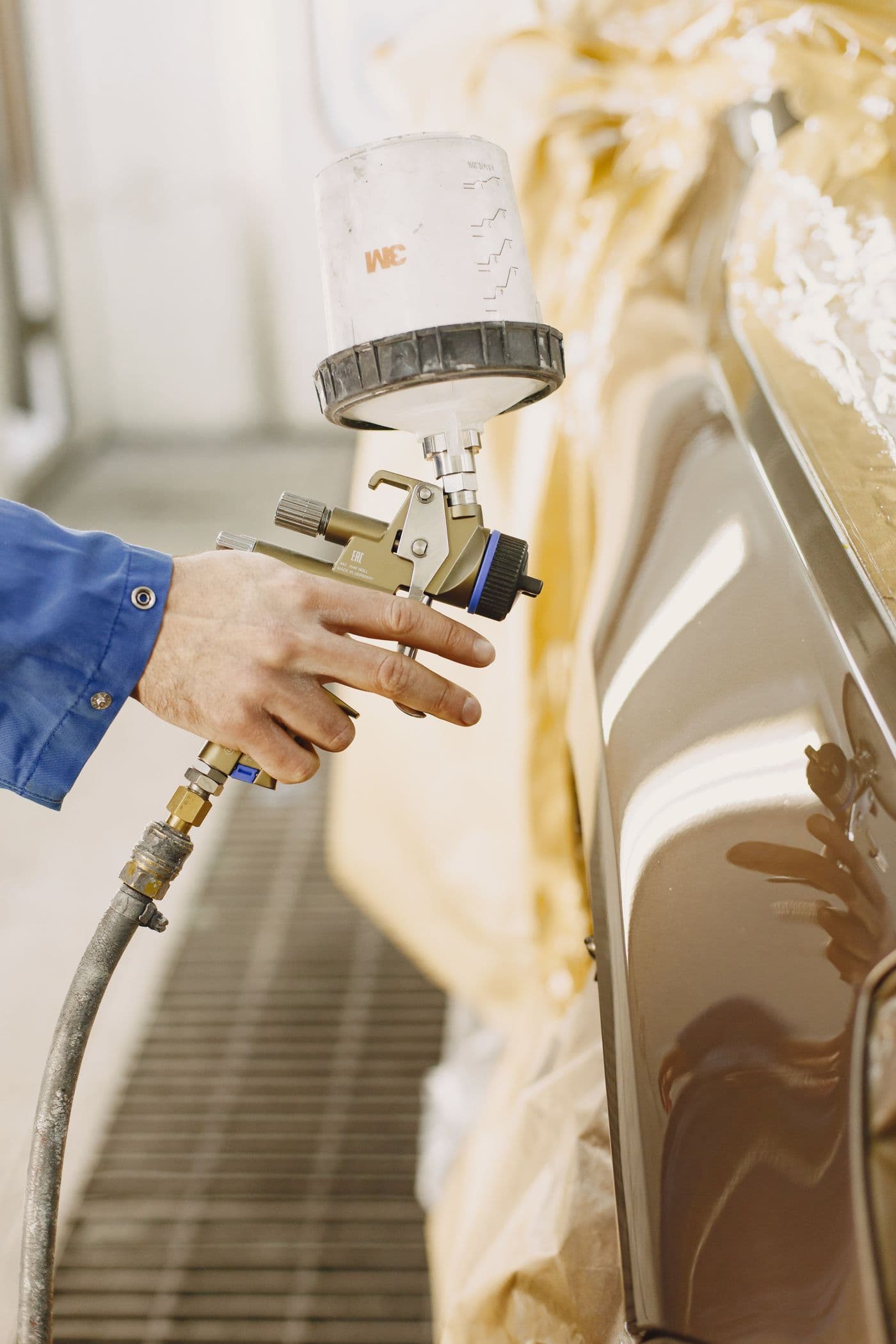 Car panel being spray-painted in our body shop booth